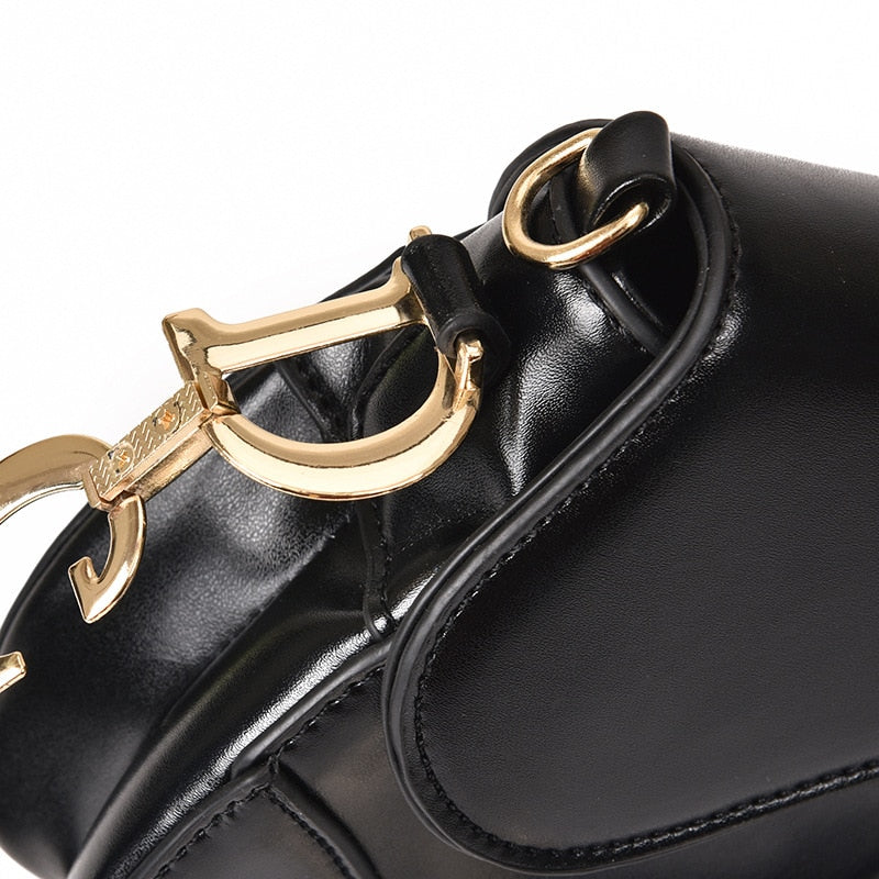 Zwarte imitatieleren tas met gouden gesp, close-up detailweergave | Boutique Moda