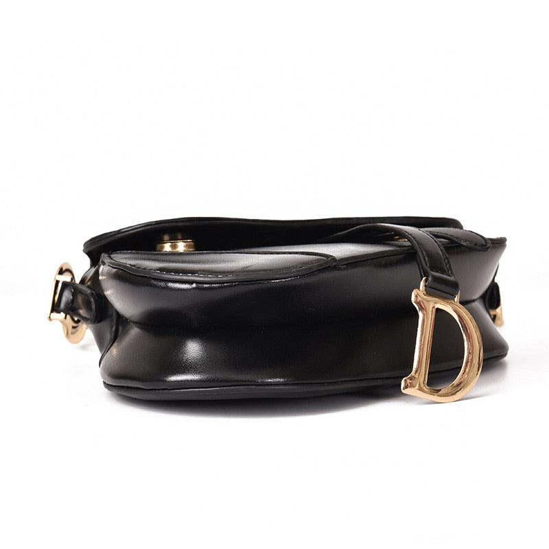 Zwarte glanzende schoudertas met gouden D-hanger, vrijstaand gefotografeerd | Boutique Moda