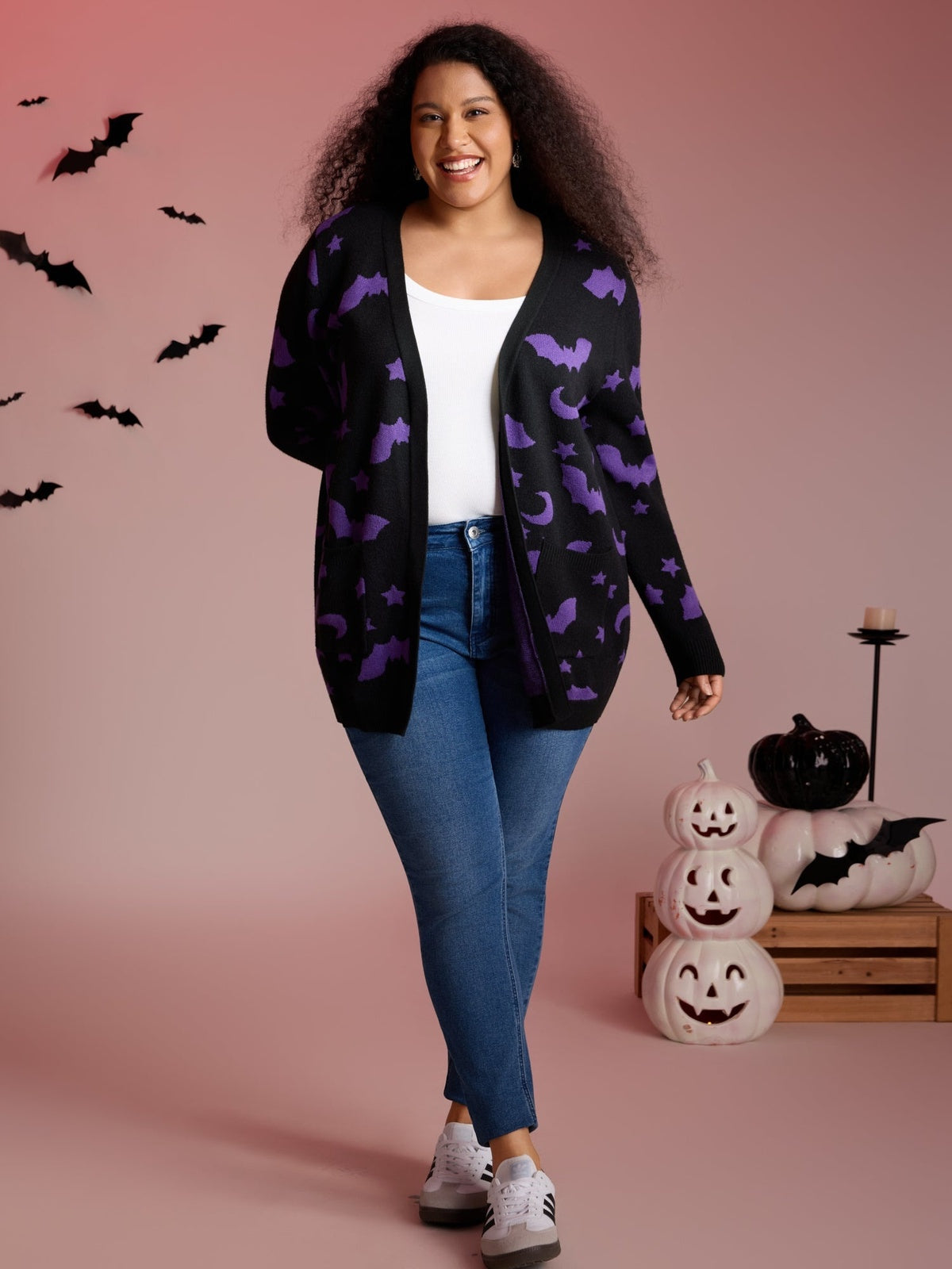 Vrouw in het vleermuis vest met jeans, volledige lengte