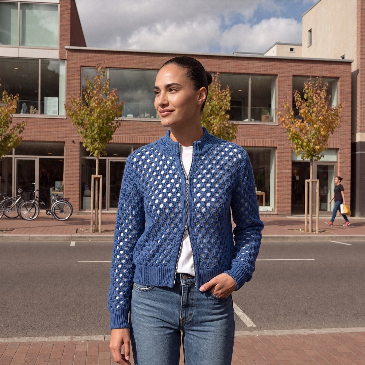 Vrouw in een blauw opengewerkt vest met rits in een winkelstraat in Rotterdam