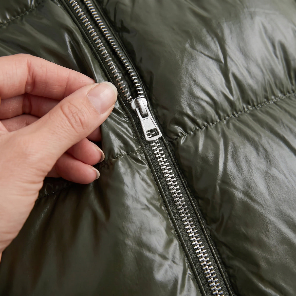 Close-up van glanzende groene jas met rits, gedragen door persoon | Boutique Moda