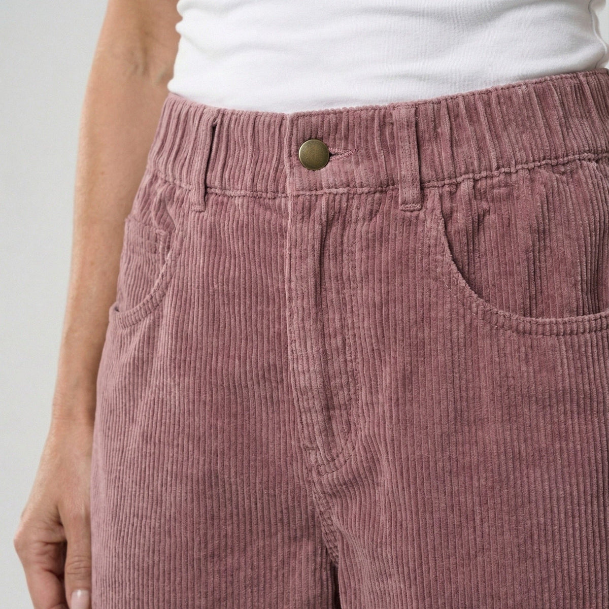 Close-up van oudroze corduroy broek met hoge taille, gedragen door model | Boutique Moda