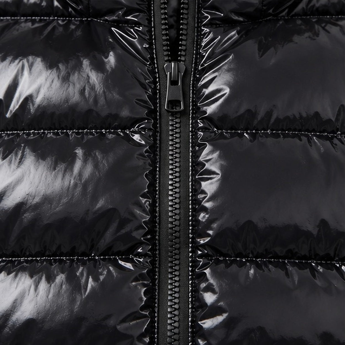Close-up van glanzende zwarte gewatteerde jas met zichtbare rits en naden | Boutique Moda