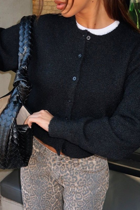 Zwart kort vest met een broek met luipaardprint en een gevlochten tas