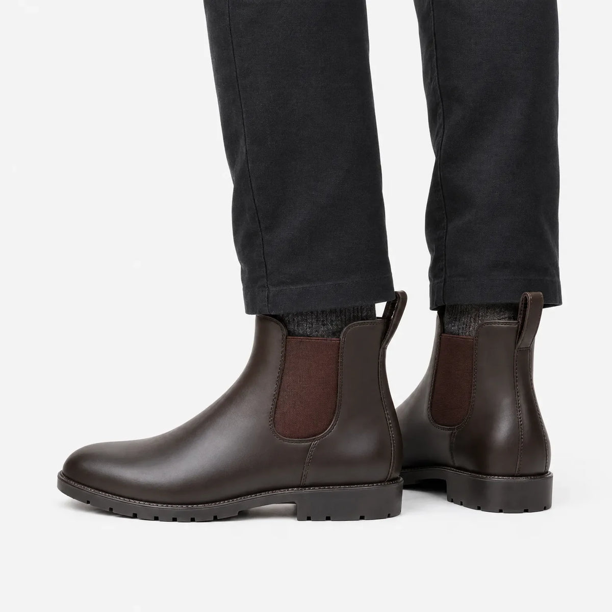 Bruine Chelsea-regenlaarzen met een donkergrijze broek, zijaanzicht