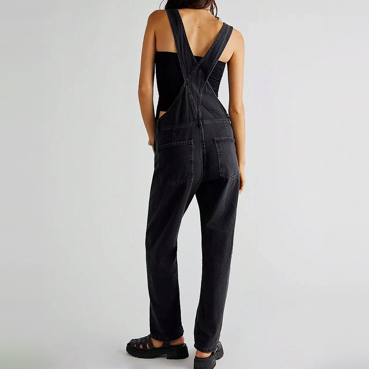 Zwarte denim tuinbroek met kruisbanden, gedragen door vrouw, achteraanzicht | Boutique Moda