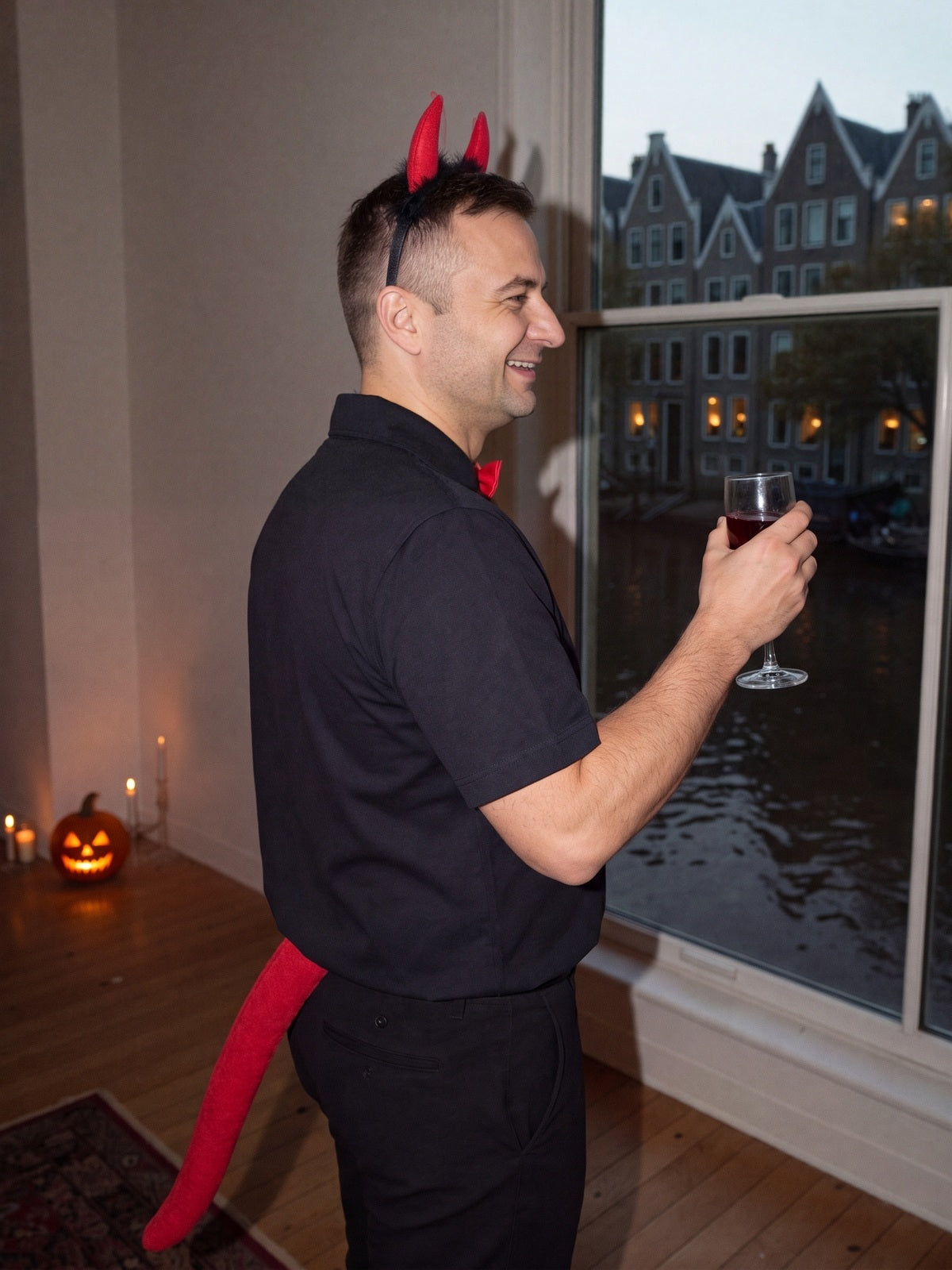 Model met de duivel set en een glas op een Halloweenfeest