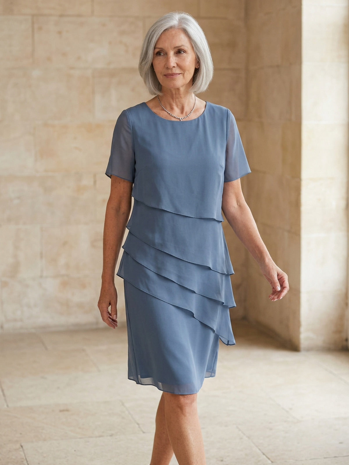 Blauwgrijze chiffon jurk met korte mouwen, gelaagde rok, gedragen door vrouw | Boutique Moda
