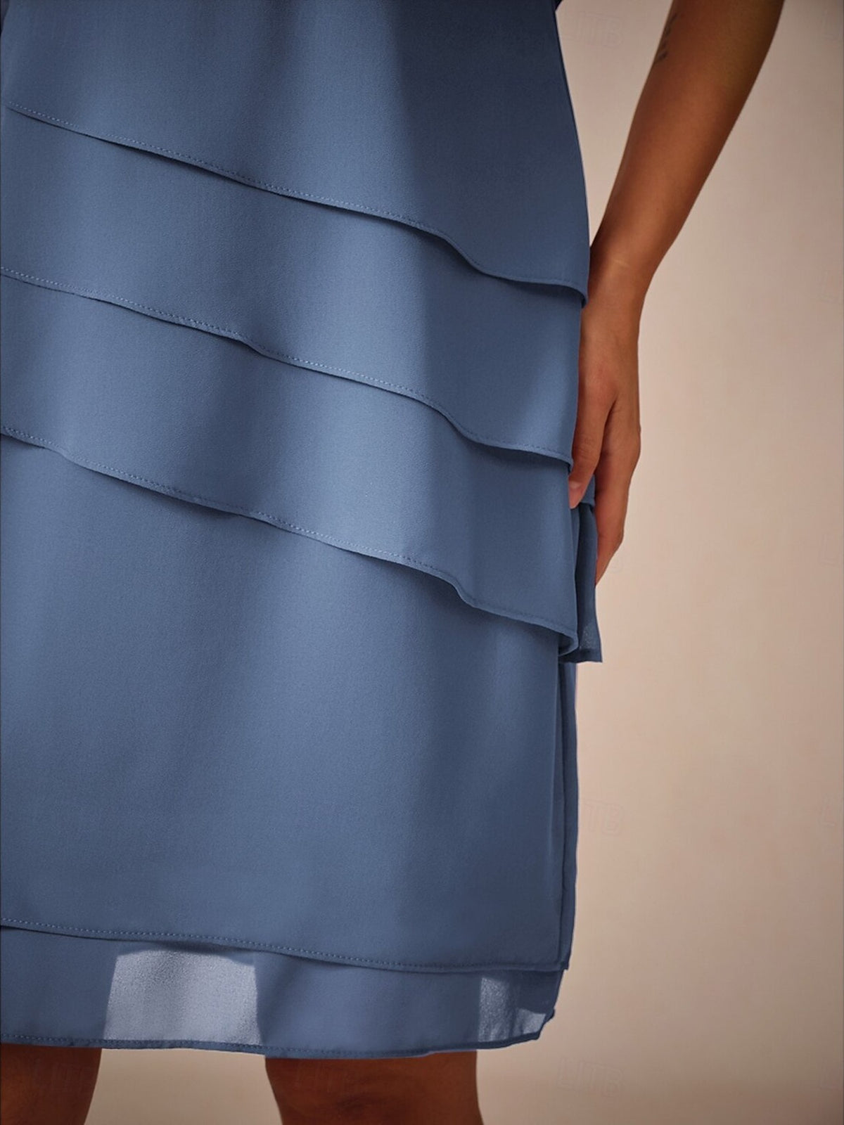 Blauwe gelaagde chiffon jurk met asymmetrische zoom, gedragen door model | Boutique Moda
