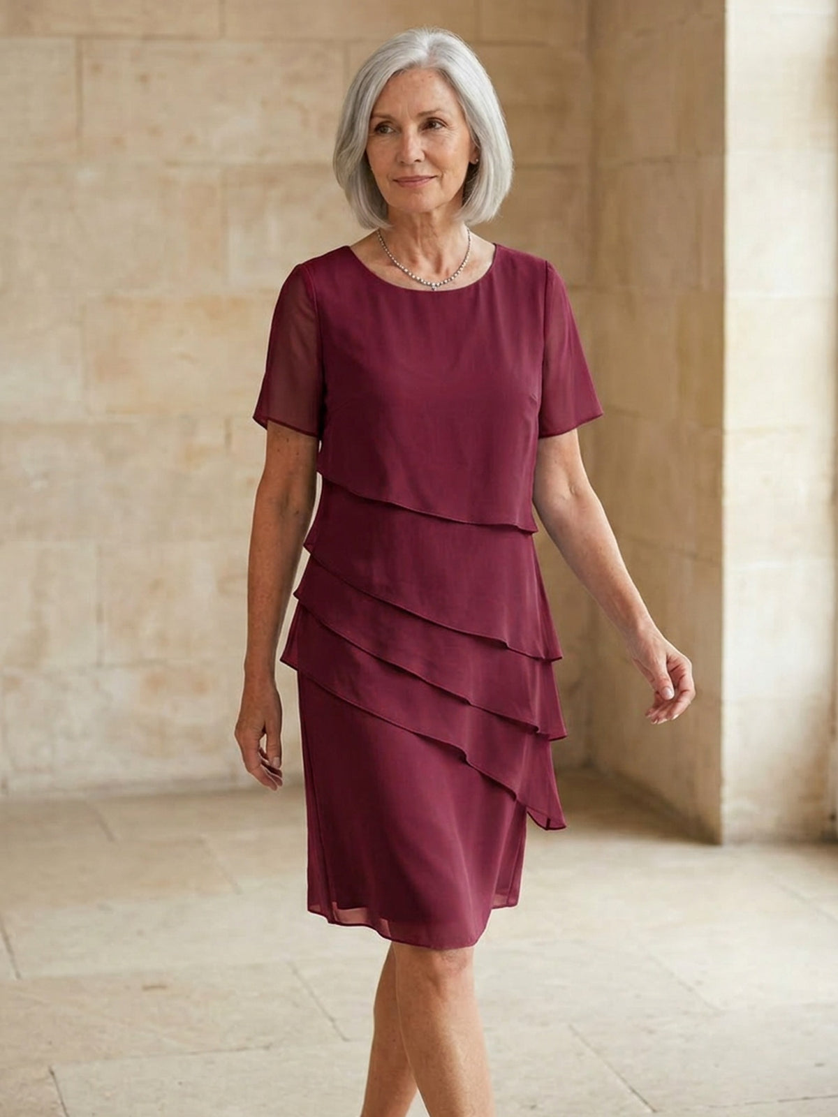 Bordeauxrode gelaagde chiffon jurk met korte mouwen, gedragen door oudere vrouw | Boutique Moda