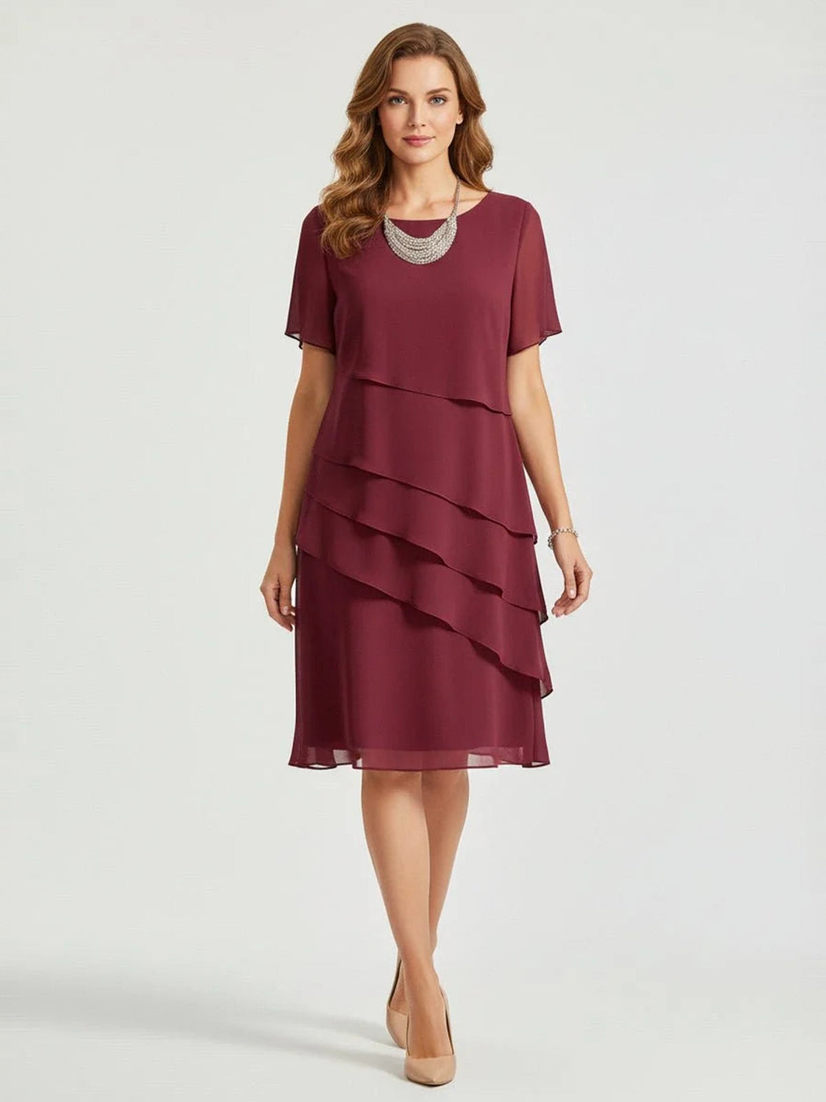 Bordeaux chiffon jurk met asymmetrische laagjes, gedragen door glimlachende vrouw | Boutique Moda