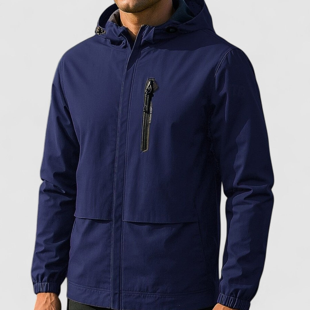 Donkerblauwe regenjas met capuchon en borstzak, gedragen door een man | Boutique Moda