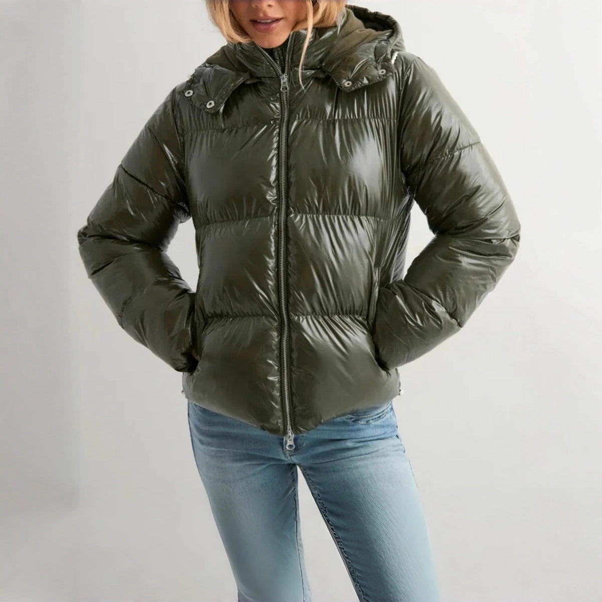 Groene glanzende winterjas met capuchon, gedragen door vrouw, met spijkerbroek | Boutique Moda