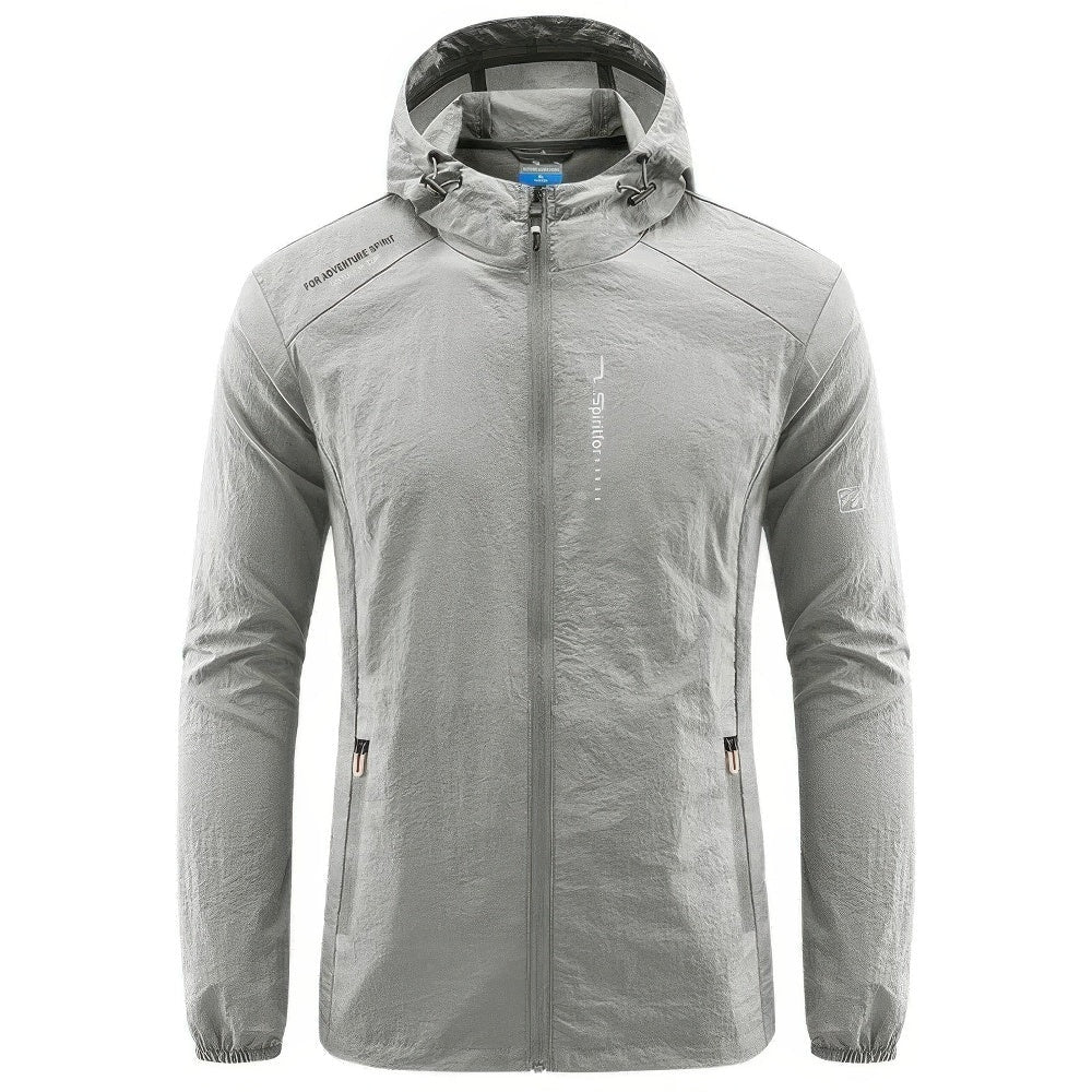Grijze sportieve outdoorjas met capuchon en ritszakken, los opgehangen getoond | Boutique Moda