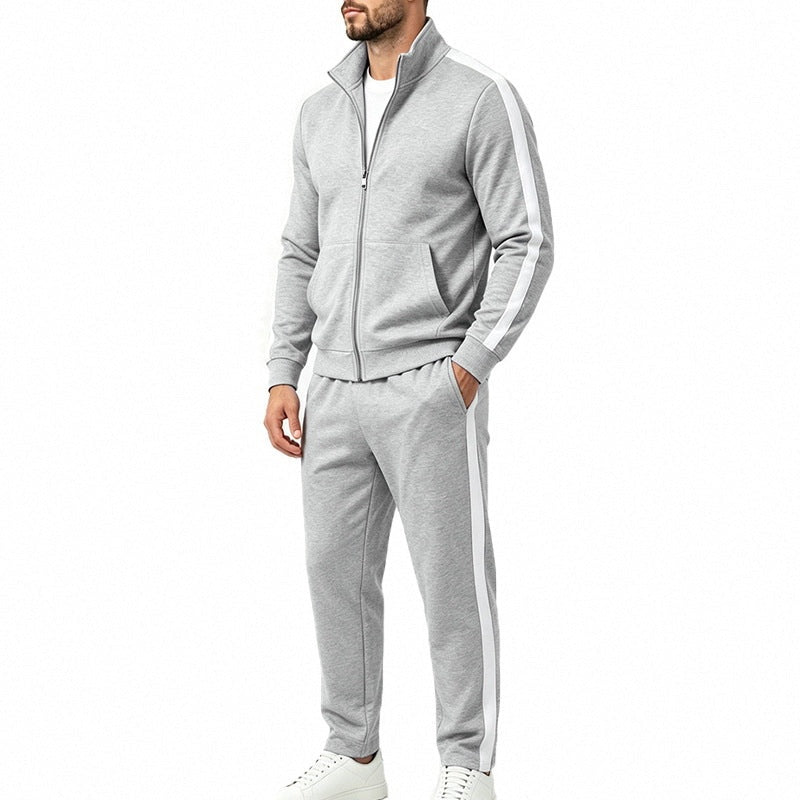 Grijs trainingspak met witte contraststreep en opstaande kraag, gedragen door man | Boutique Moda