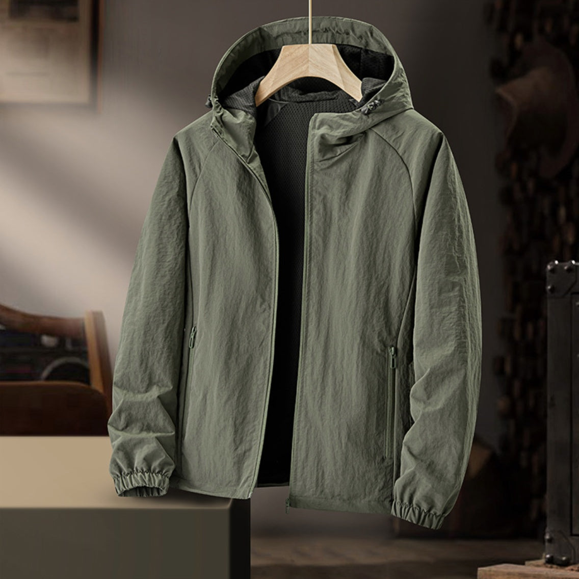 Groen windjas met capuchon, open rits, hangend op een hanger | Boutique Moda