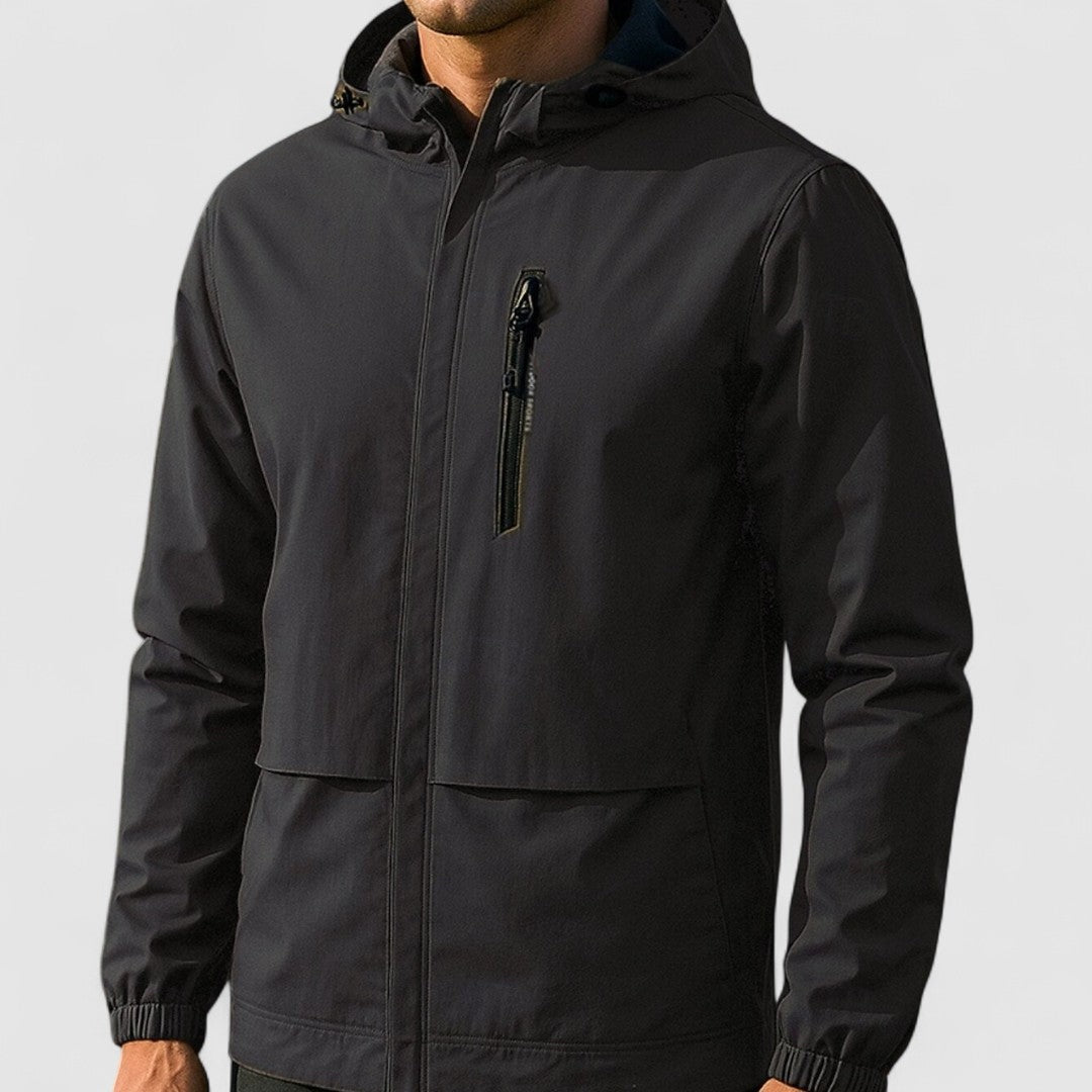 Zwarte regenjas met capuchon en ritszak, gedragen door een man | Boutique Moda