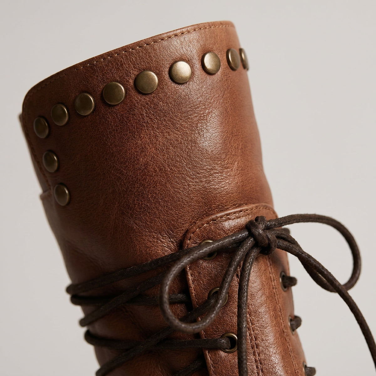 Bruine veterlaars met studs en veters, close-up detailfoto | Boutique Moda