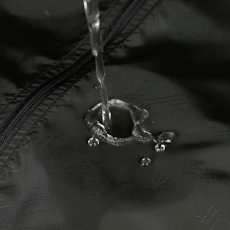 Waterdruppels parelen af op zwart waterafstotend jasmateriaal met ritssluiting zichtbaar | Boutique Moda