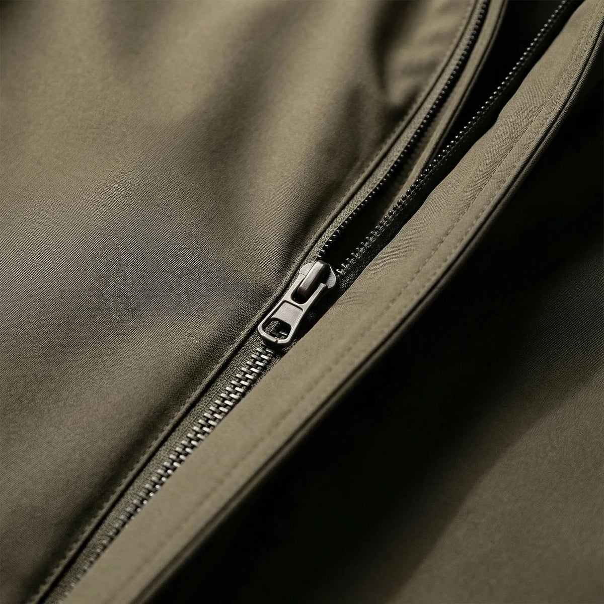 Close-up van verborgen rits op olijfgroene regenjas met capuchon | Boutique Moda