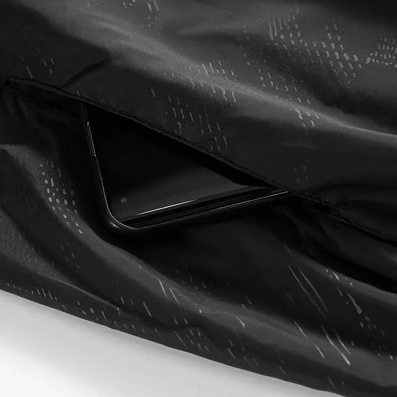 Zwarte jas met binnenzak, smartphone zichtbaar in opbergvak, close-up detail | Boutique Moda