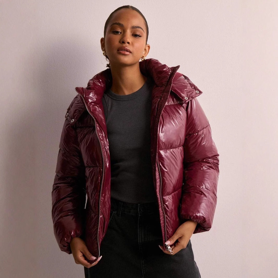 Glanzende bordeauxrode gewatteerde jas met capuchon, gedragen door vrouw, kort model | Boutique Moda