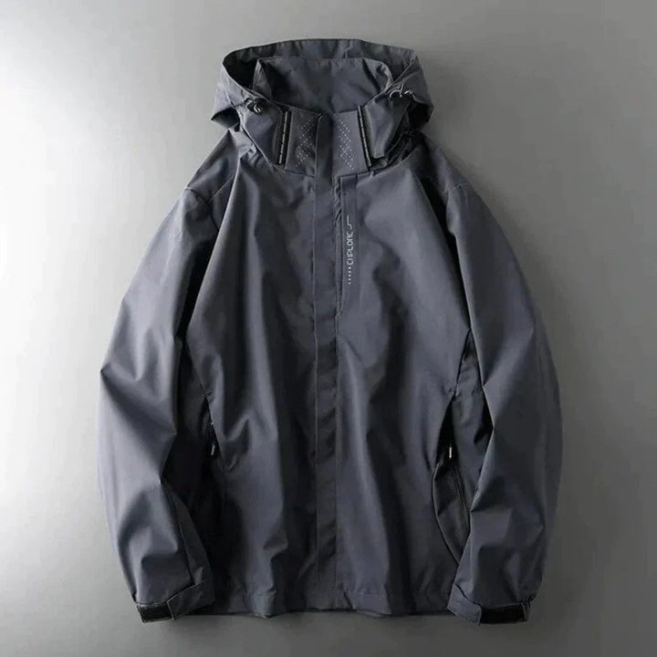 Grijze windbreaker met capuchon en ritszakken, plat neergelegd fotografeerd | Boutique Moda