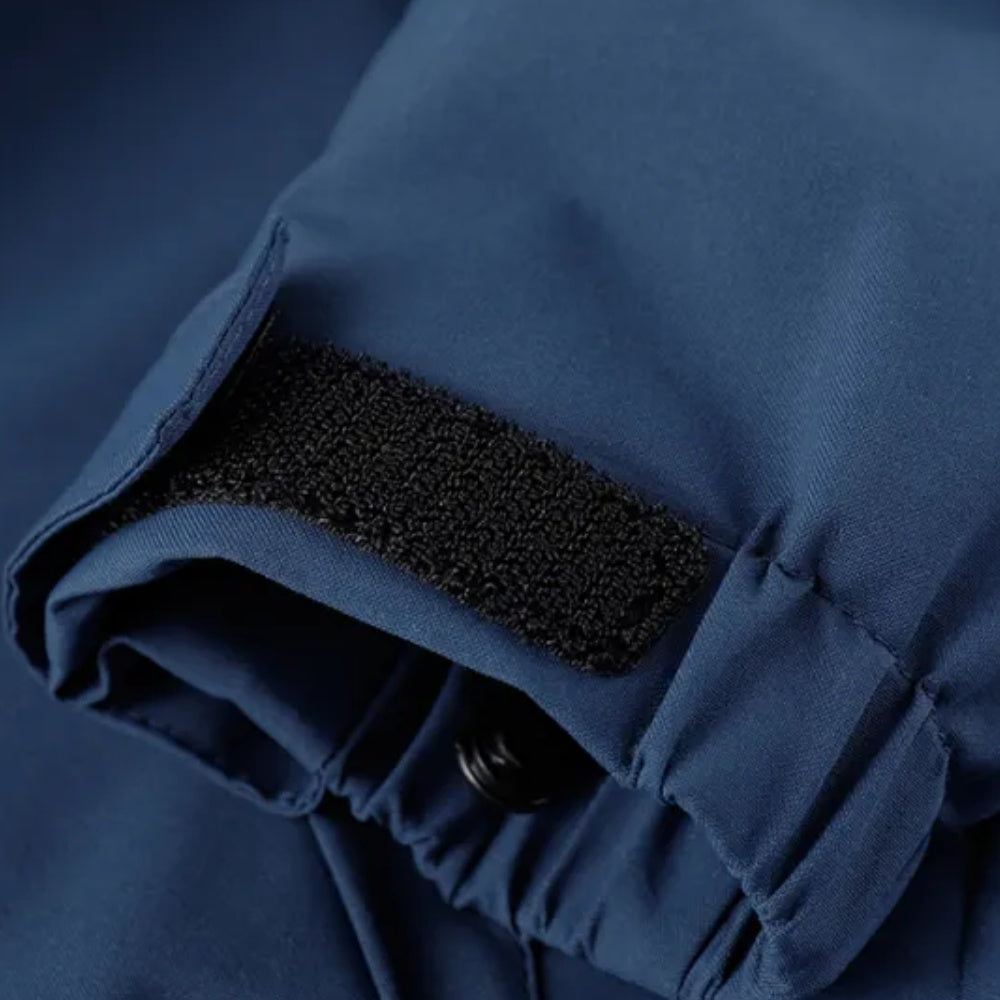 Close-up van blauwe jas met klittenband sluiting en drukknoop detail | Boutique Moda