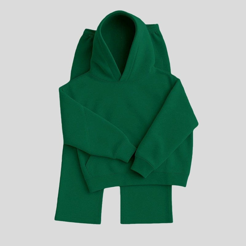 Groene hoodie en joggingbroek plat uitgestald op lichtgrijze achtergrond | Boutique Moda