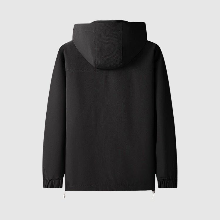 Zwart windjack met capuchon, achteraanzicht, plat gefotografeerd op lichte achtergrond | Boutique Moda