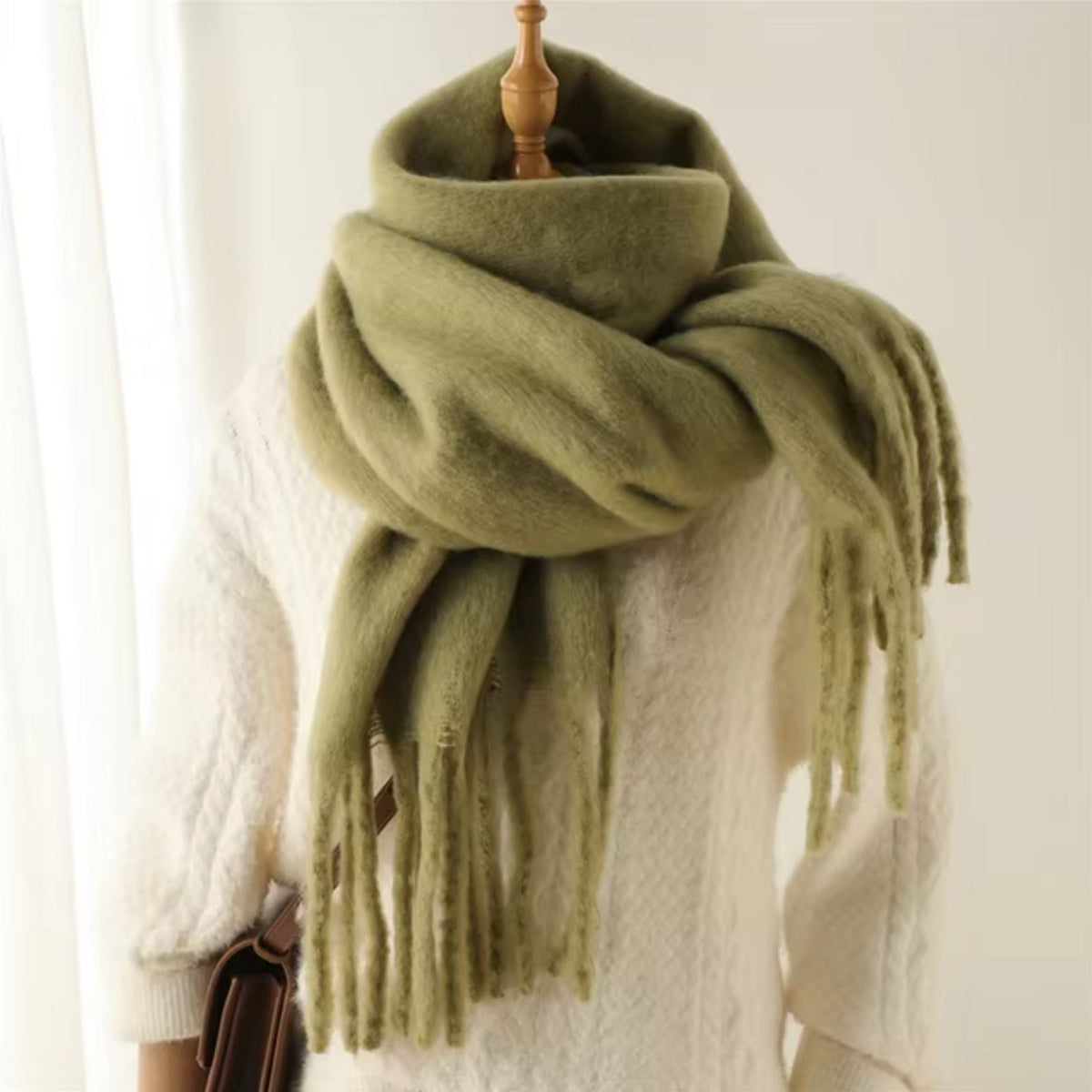 Groene sjaal met franjes om paspop gewikkeld, effen kleur getoond | Boutique Moda
