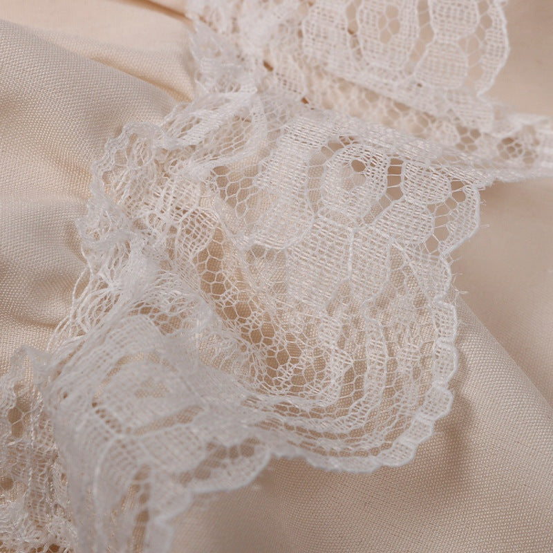 Close-up van crème kanten ruche op beige stof, plat gefotografeerd | Boutique Moda
