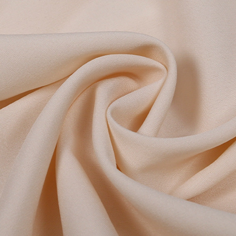 Perzikkleurige stof met gedraaide plooi, close-up zonder persoon of mannequin | Boutique Moda