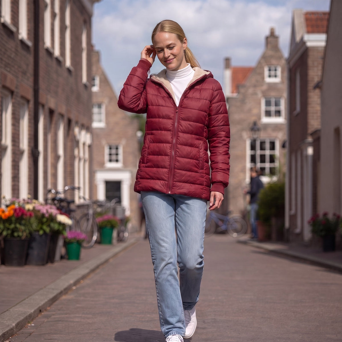 Vrouw in een bordeauxrode gewatteerde jas met teddyvoering in Haarlem