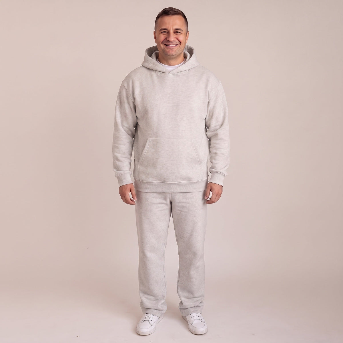 Man draagt lichtgrijze joggingset met hoodie, volledige outfit zichtbaar | Boutique Moda