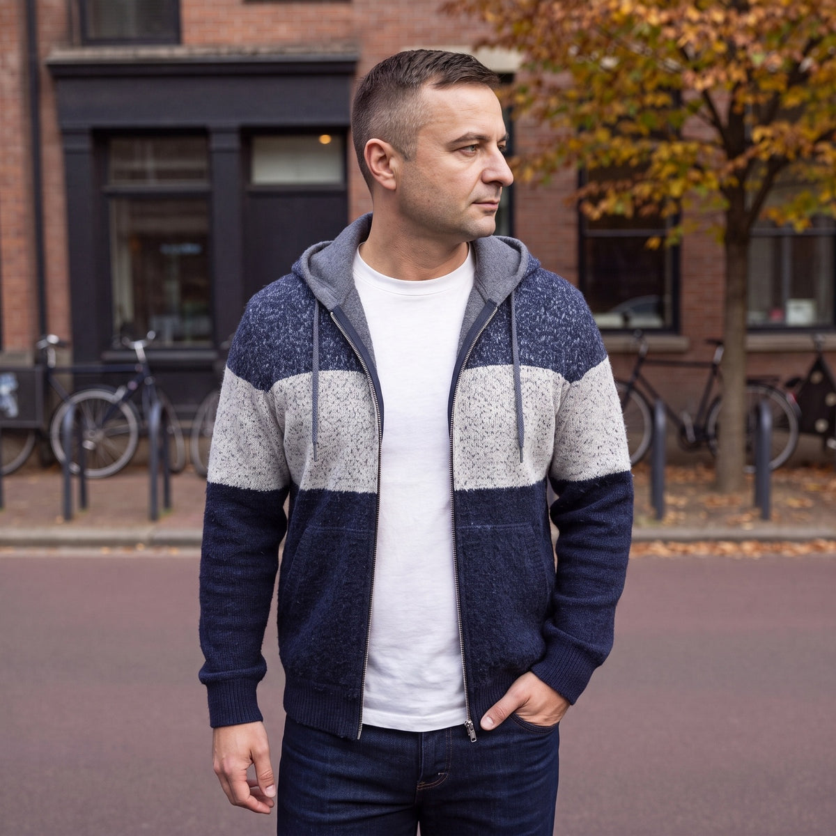 Man in het marineblauwe gebreide vest met capuchon op straat | Boutique Moda