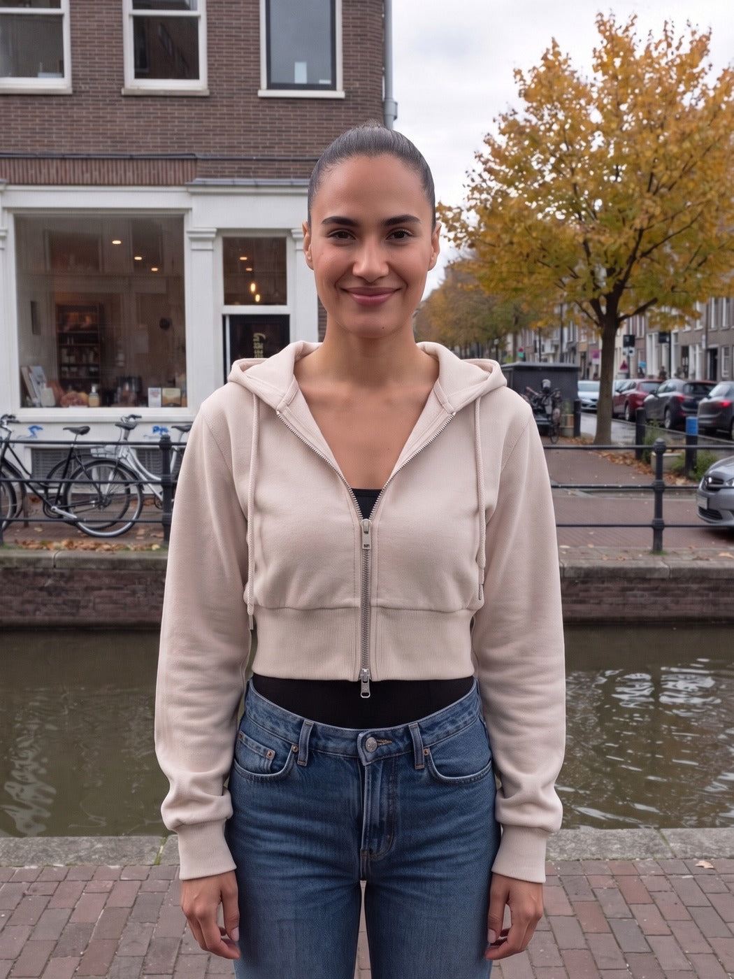 Vrouw draagt het korte vest in beige aan een gracht in Amsterdam | Boutique Moda