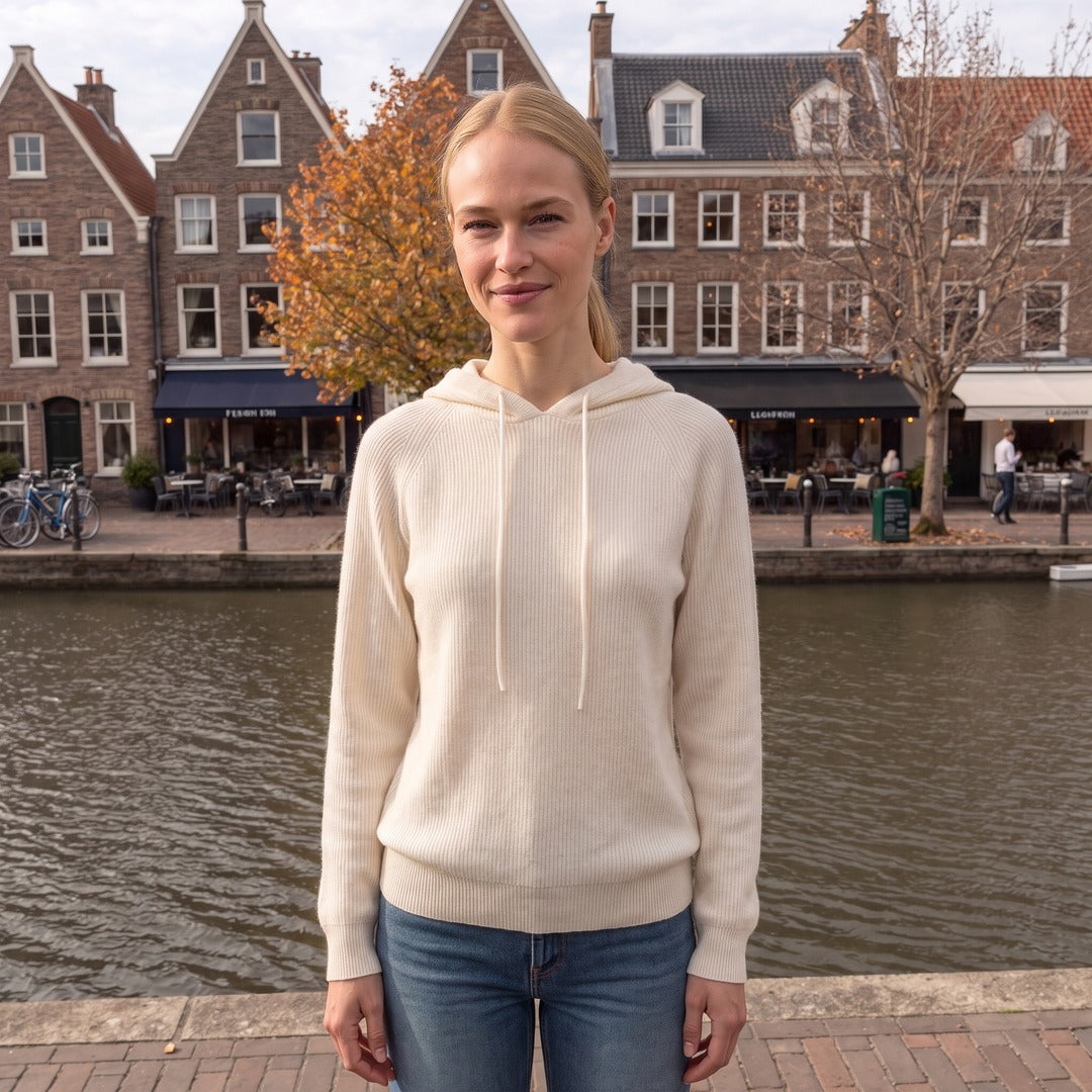 Vrouw draagt de crèmekleurige gebreide hoodie aan een gracht in Leiden | Boutique Moda