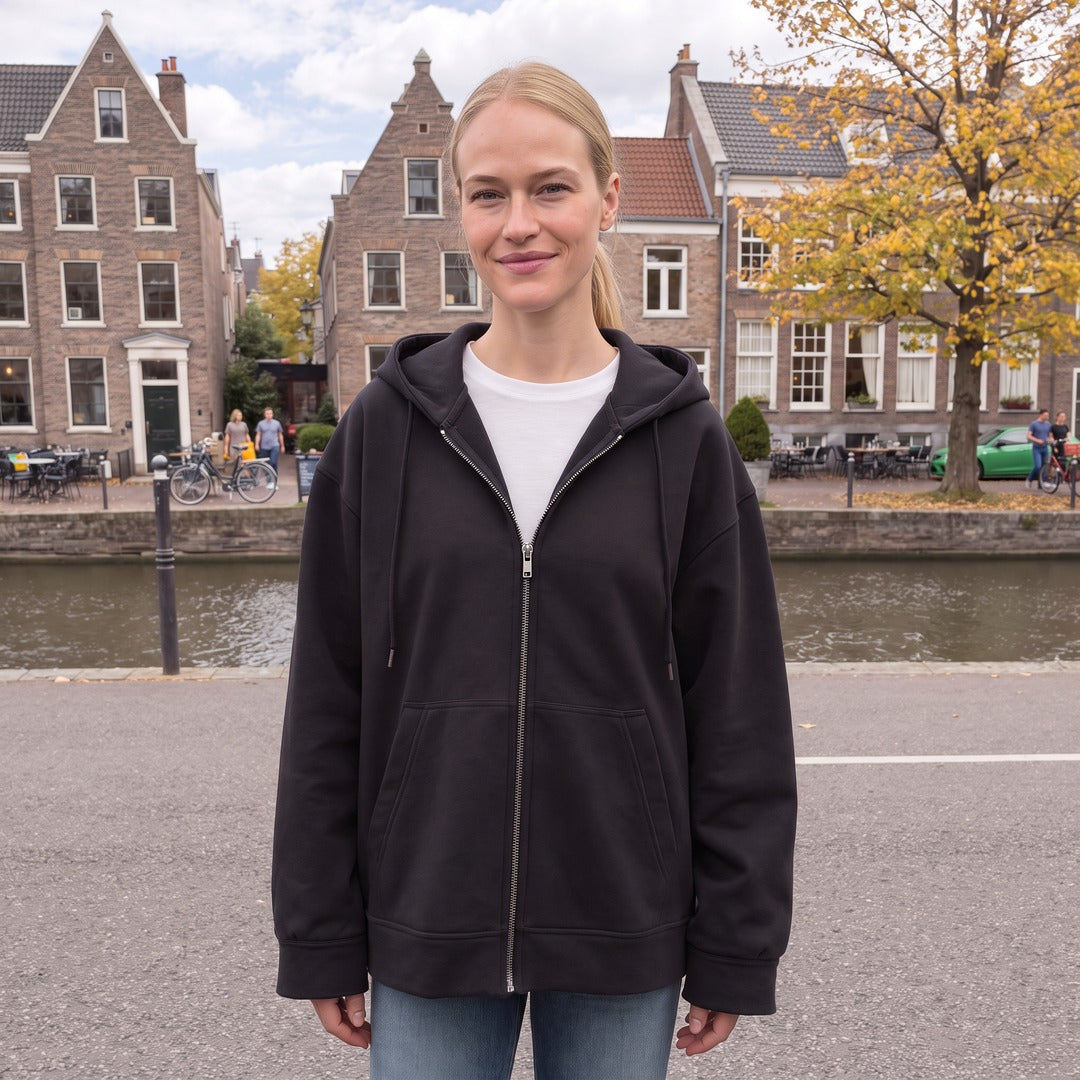 Vrouw draagt het zwarte oversized vest met capuchon in een straat in Utrecht | Boutique Moda