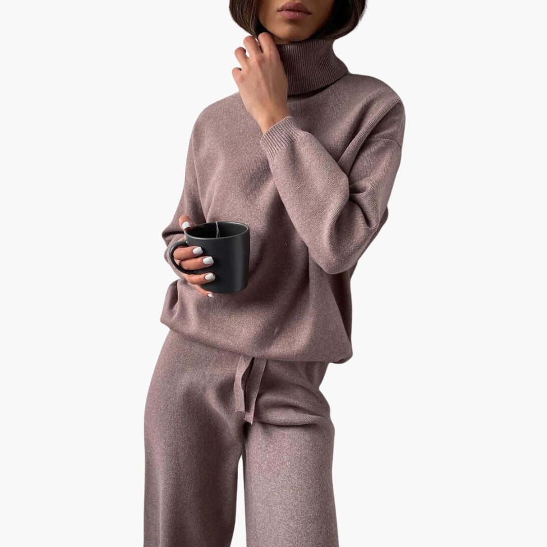 Gebreid huispak voor dames in taupe met col en wijde broek, met een mok in de hand