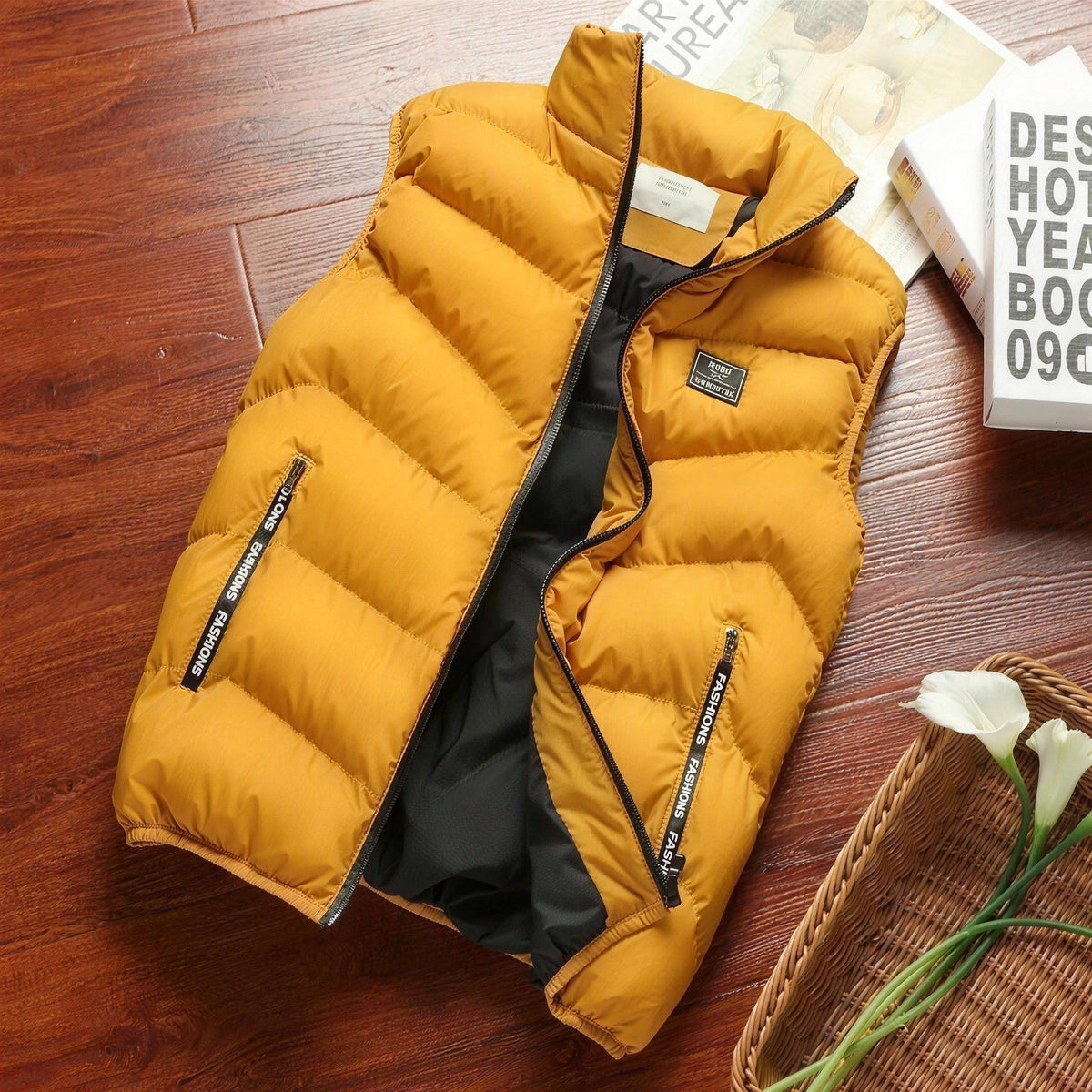Okergele gewatteerde herenbodywarmer met opstaande kraag, plat neergelegd op houten ondergrond | Boutique Moda