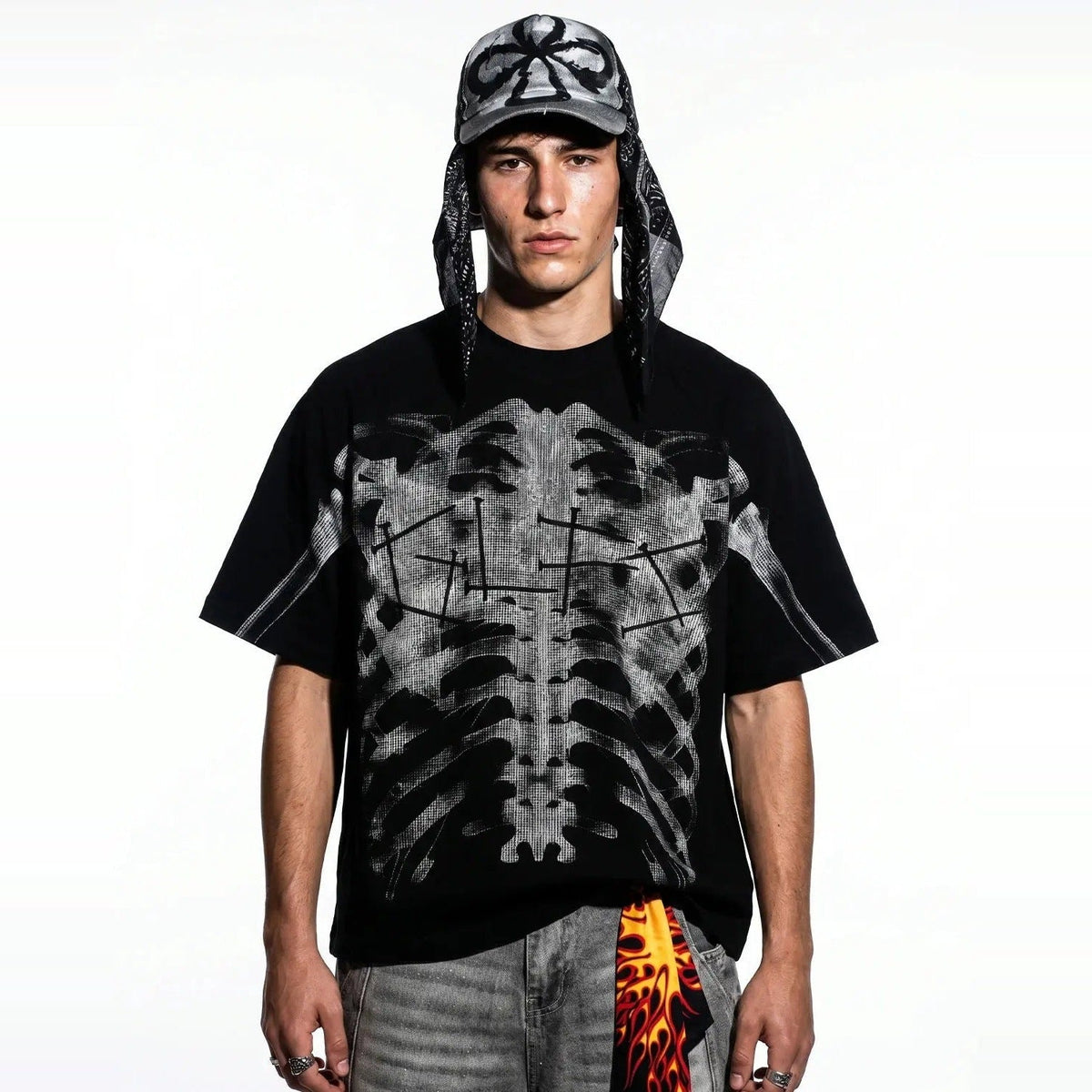 Zwart oversized T-shirt met röntgen ribbenkast print, gedragen door model met pet | Boutique Moda