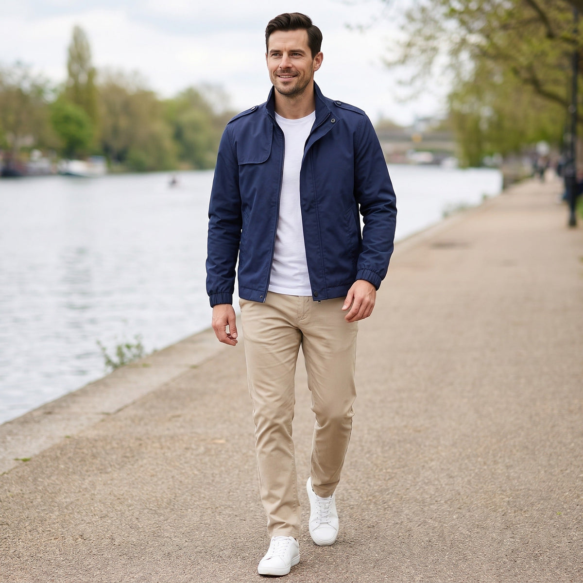 Man draagt donkerblauwe jas met wit shirt en beige broek buiten | Boutique Moda