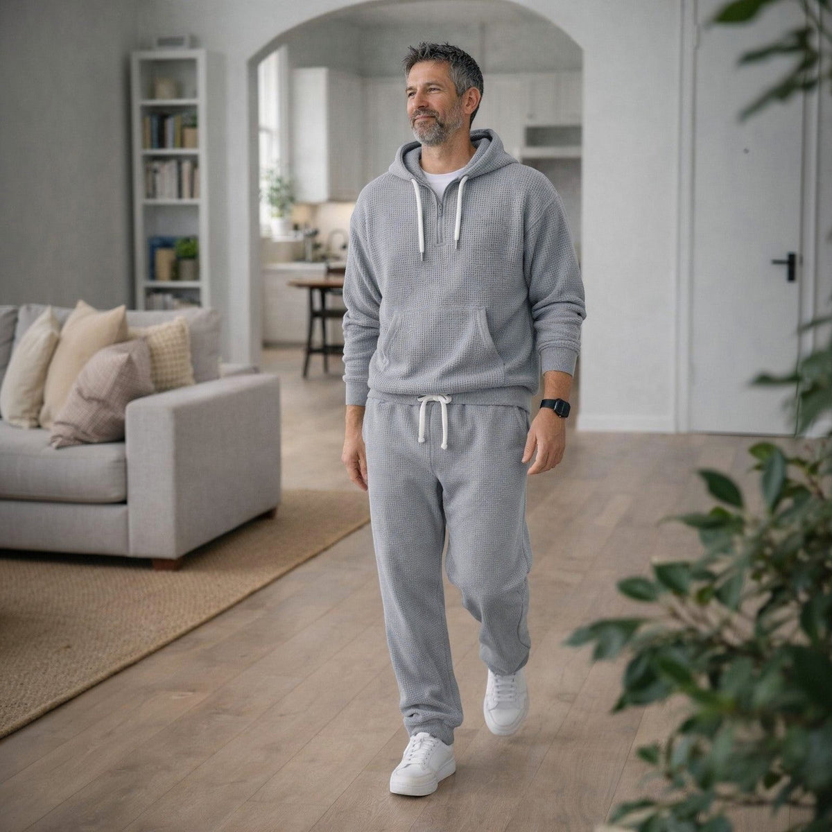 Grijze hoodie met joggingbroek, gedragen door man in woonkamer | Boutique Moda