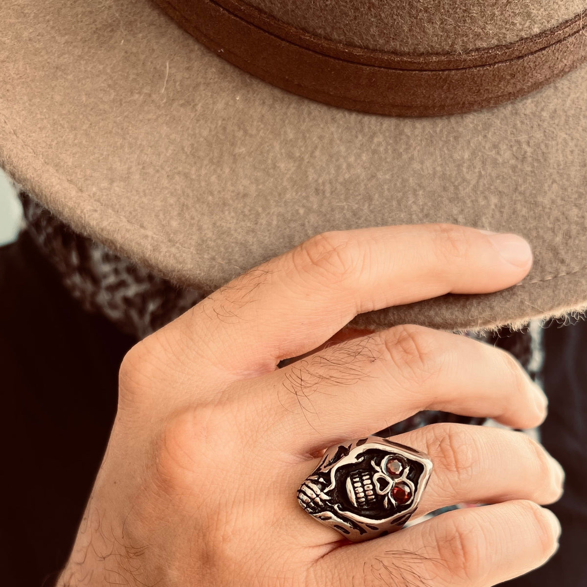 Zilverkleurige ring met doodskop en rode ogen, gedragen aan hand | Boutique Moda