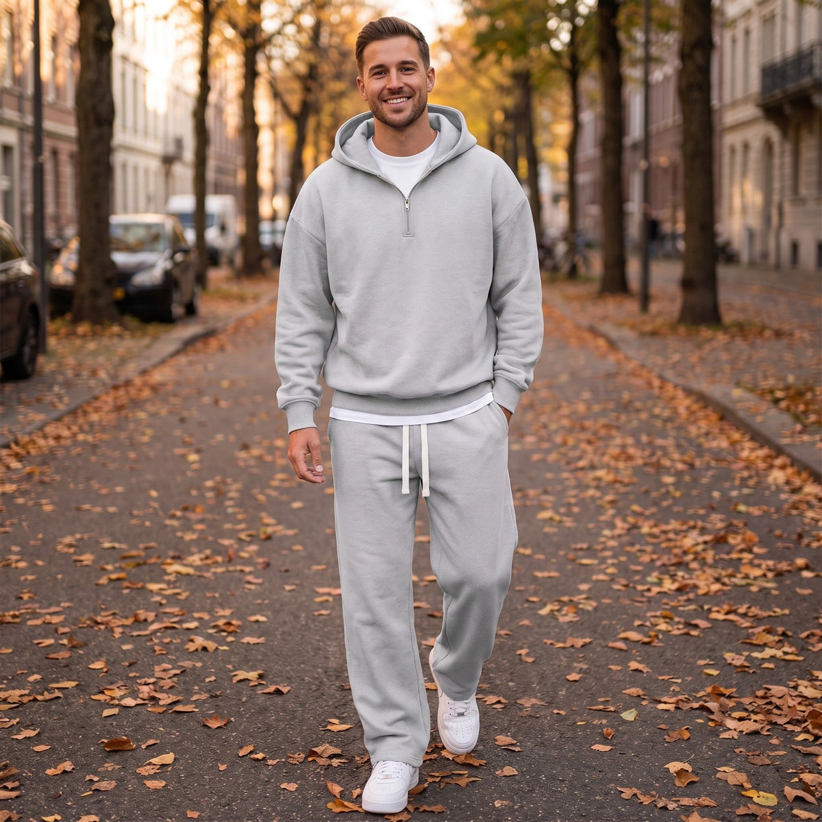 Man draagt lichtgrijs joggingpak met halfzip hoodie op straat | Boutique Moda