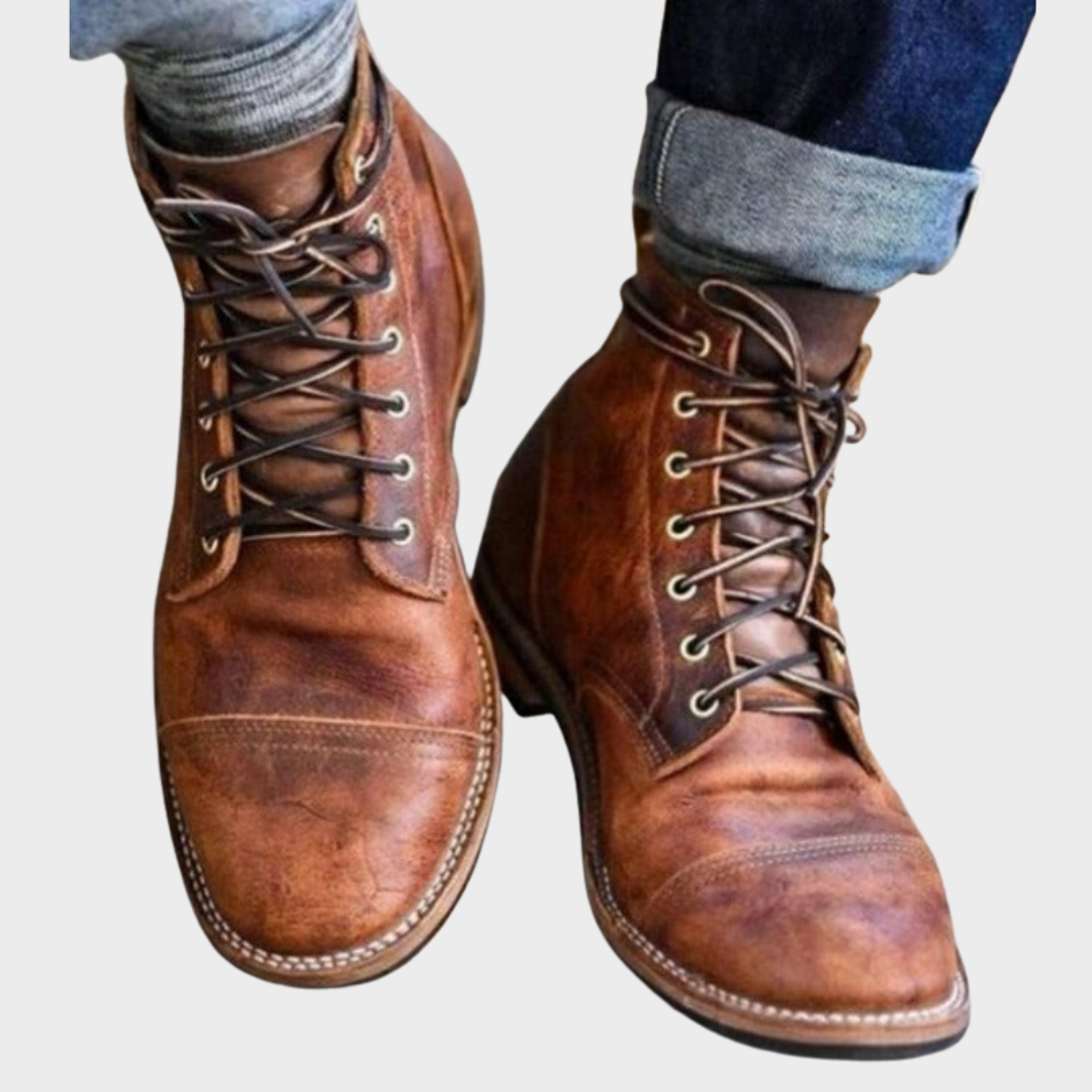 Twee bruine veterboots van kunstleer tegen een lichte achtergrond