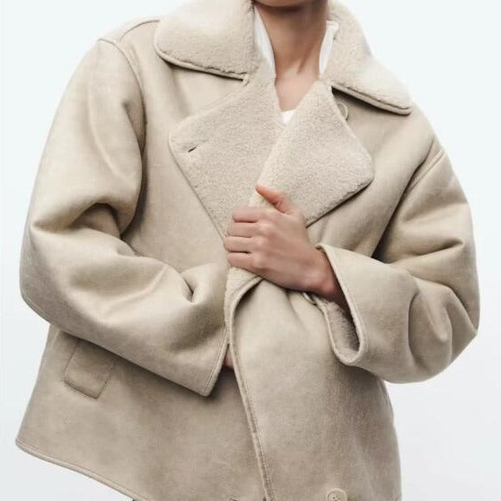 Beige oversized lammy coat met teddyvoering, gedragen door vrouw met rode lippenstift | Boutique Moda