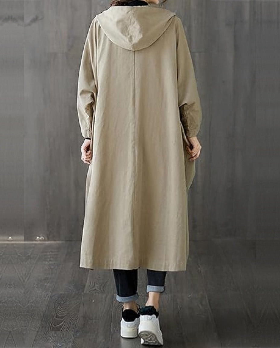 Beige lange regenjas met capuchon, gedragen door vrouw, achteraanzicht | Boutique Moda