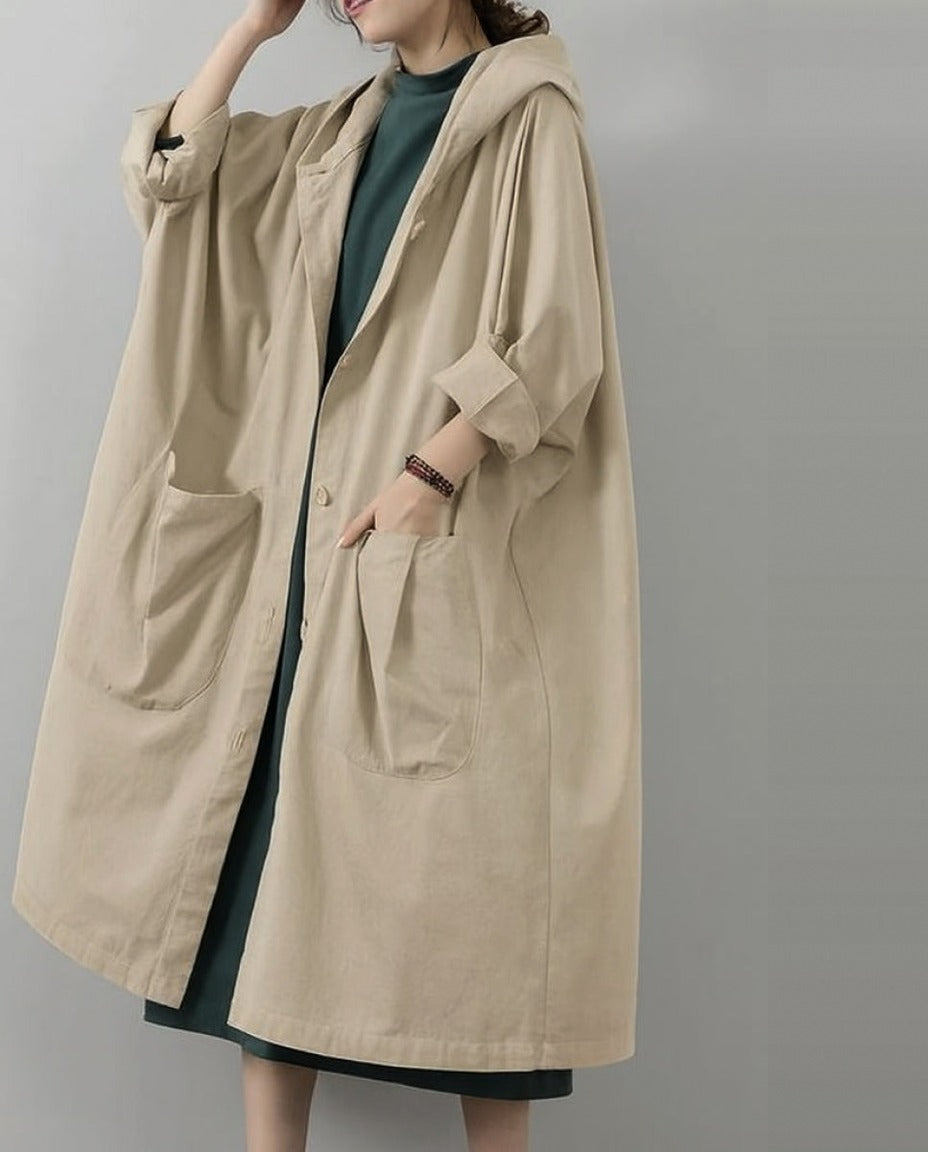 Beige lange oversized regenjas met capuchon, gedragen door vrouw model | Boutique Moda